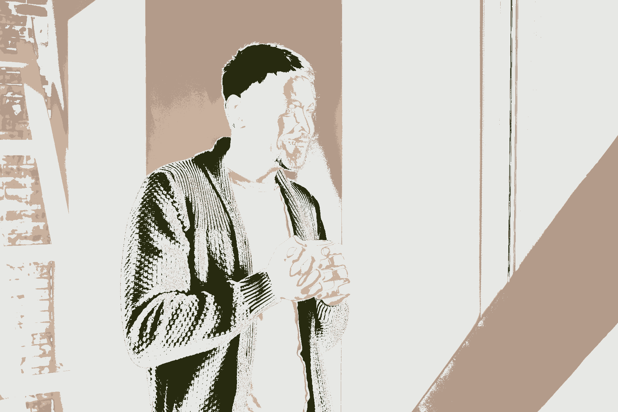 Man enjoying a cup of tea by a window.