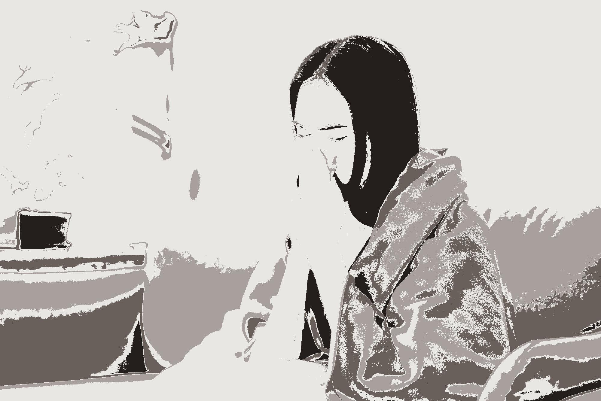 Unwell lady blowing nose in a blanket.