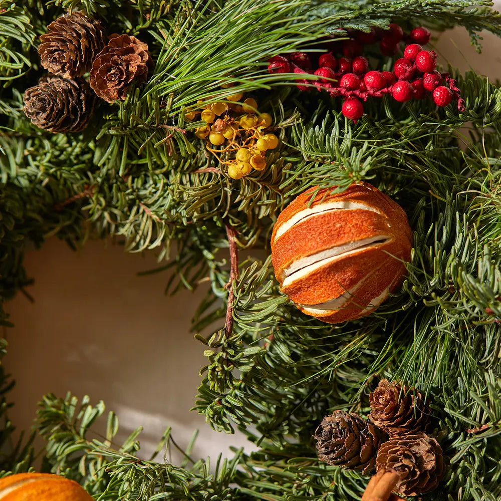 Christmas Wreath Gift with whole oranges, berries and pinecones.