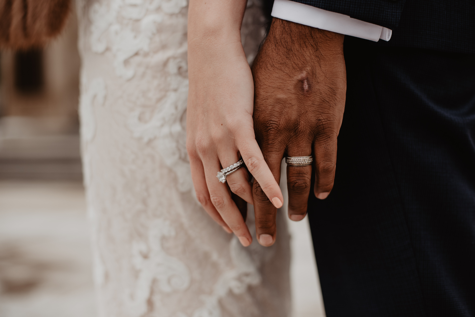 Hands of a wedding couple showing their rings.